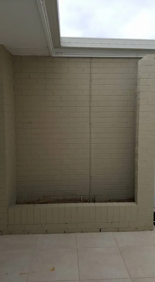 The same brick alcove before the shelves went in, bare and unlined.