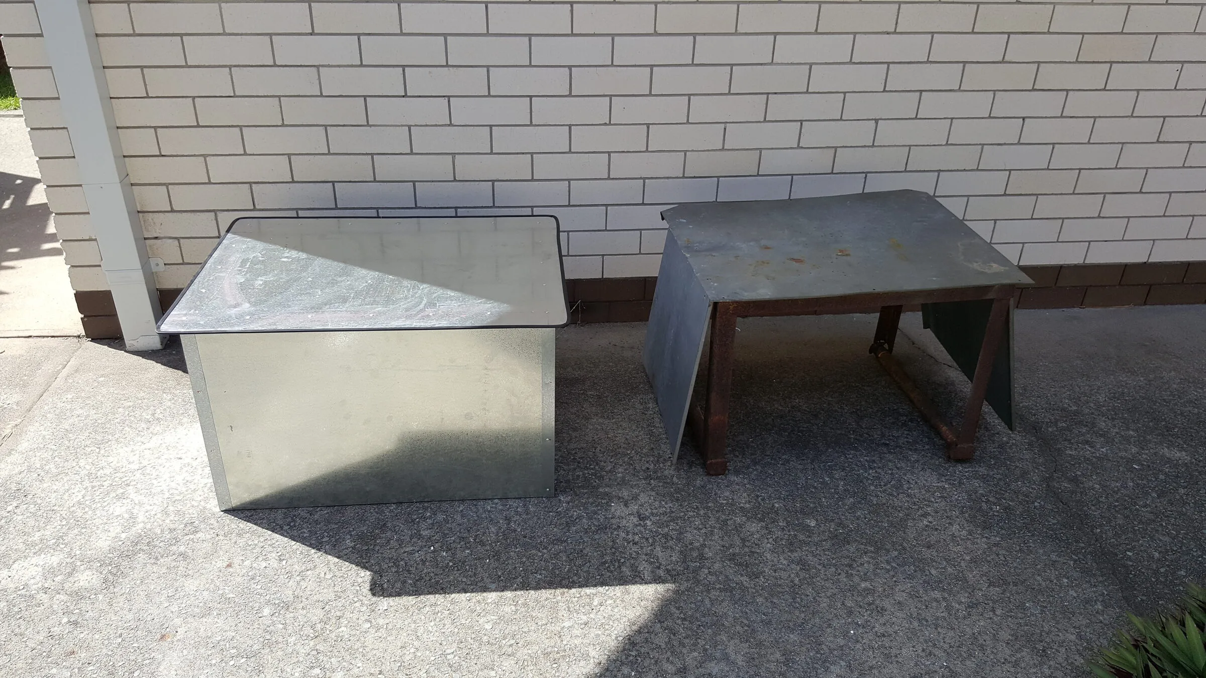 Two folded galvanised covers made up in the workshop, one sitting on a braced timber stand.