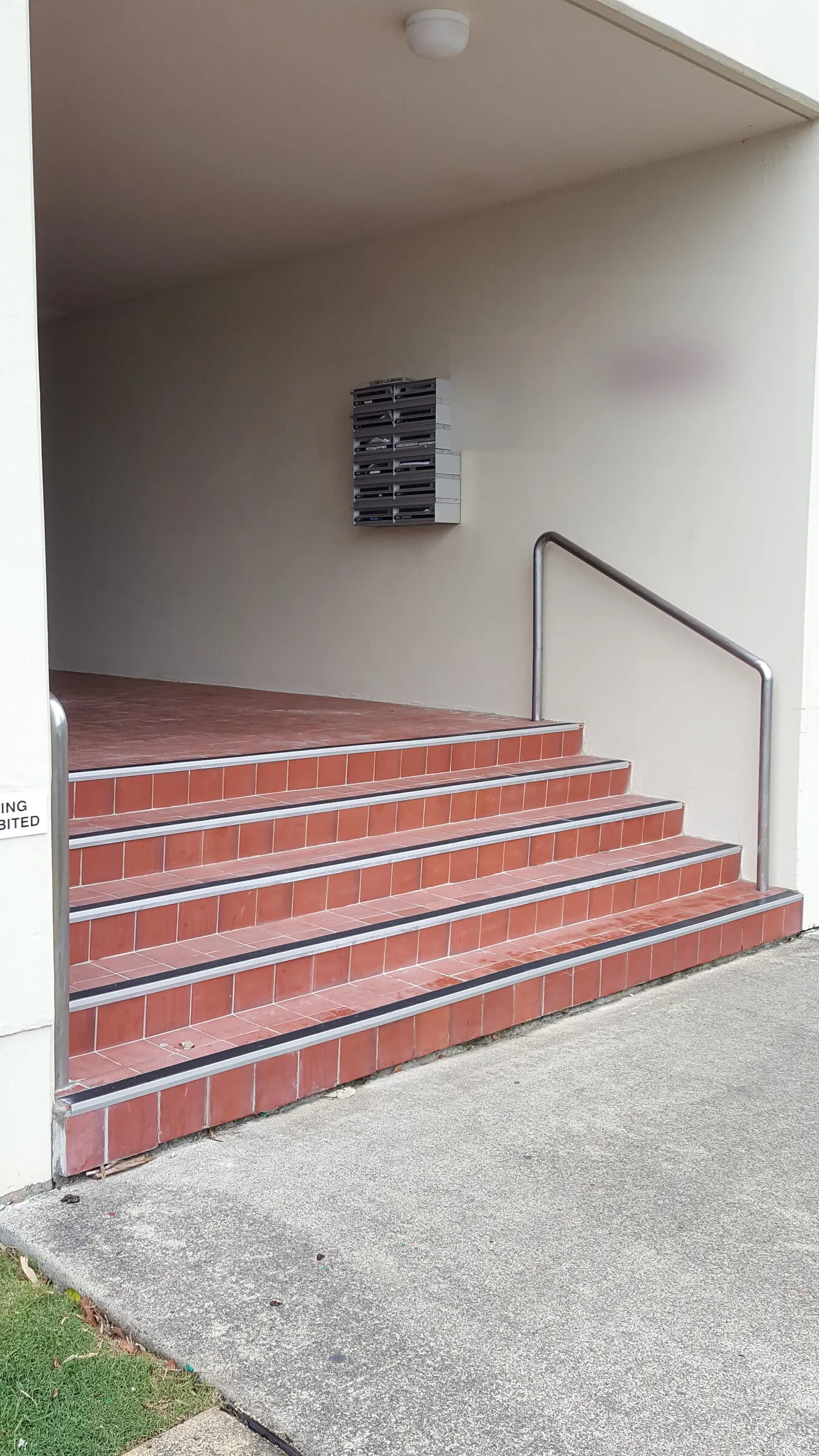 Both stainless handrails finished on the entry stairs, one to each side of the flight and returned into the wall.