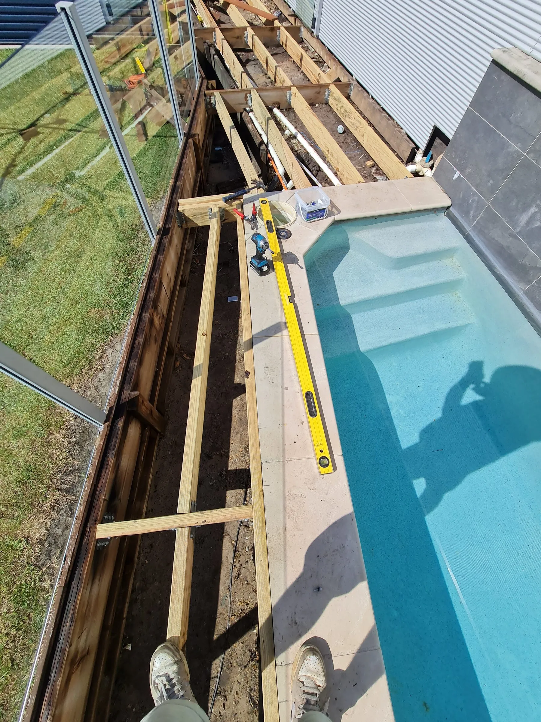 New treated joists laid in along the pool surround, levelled off the coping.