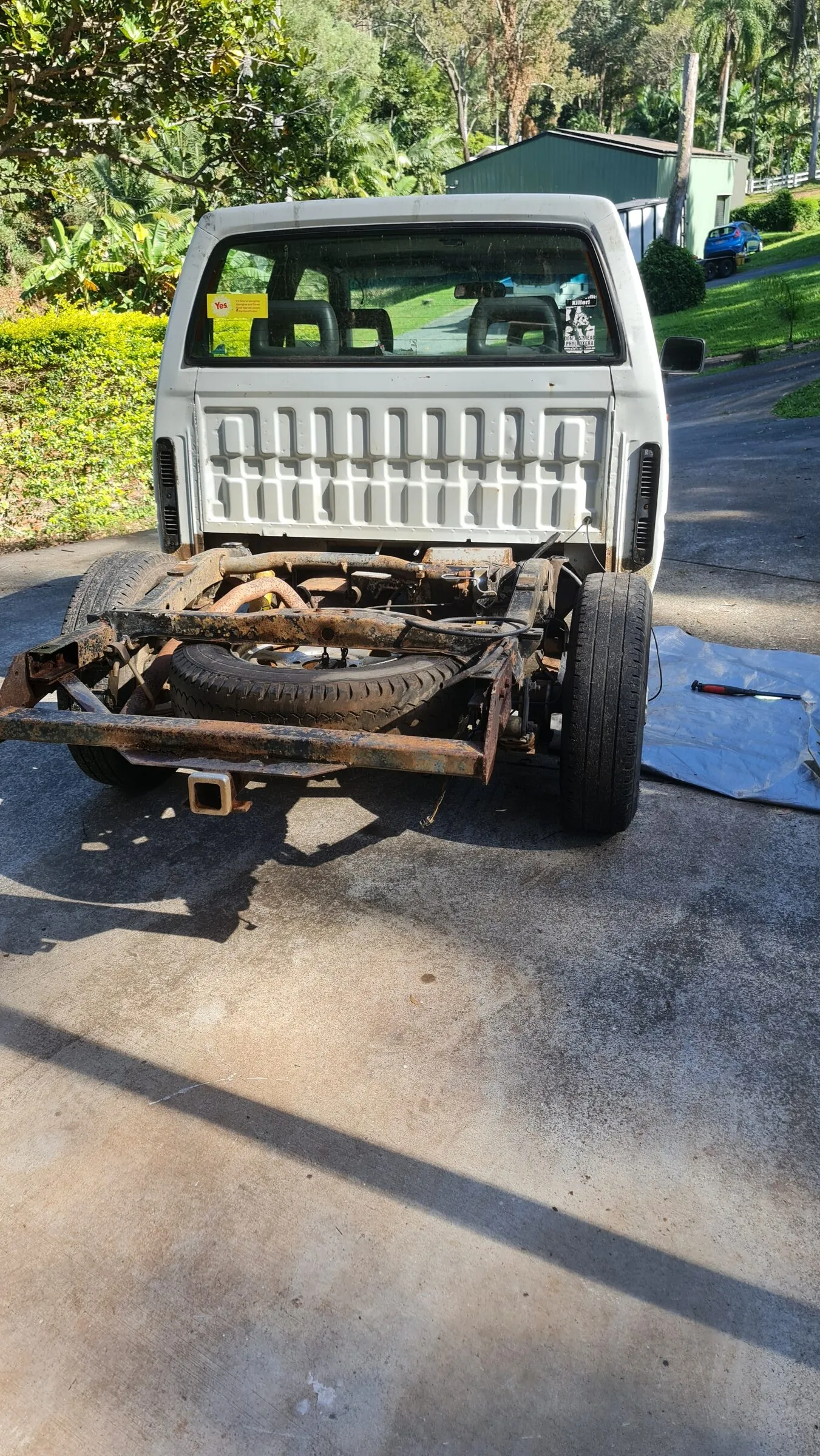 The same ute with the tray off, chassis rails and spare wheel exposed ready for the rebuild.
