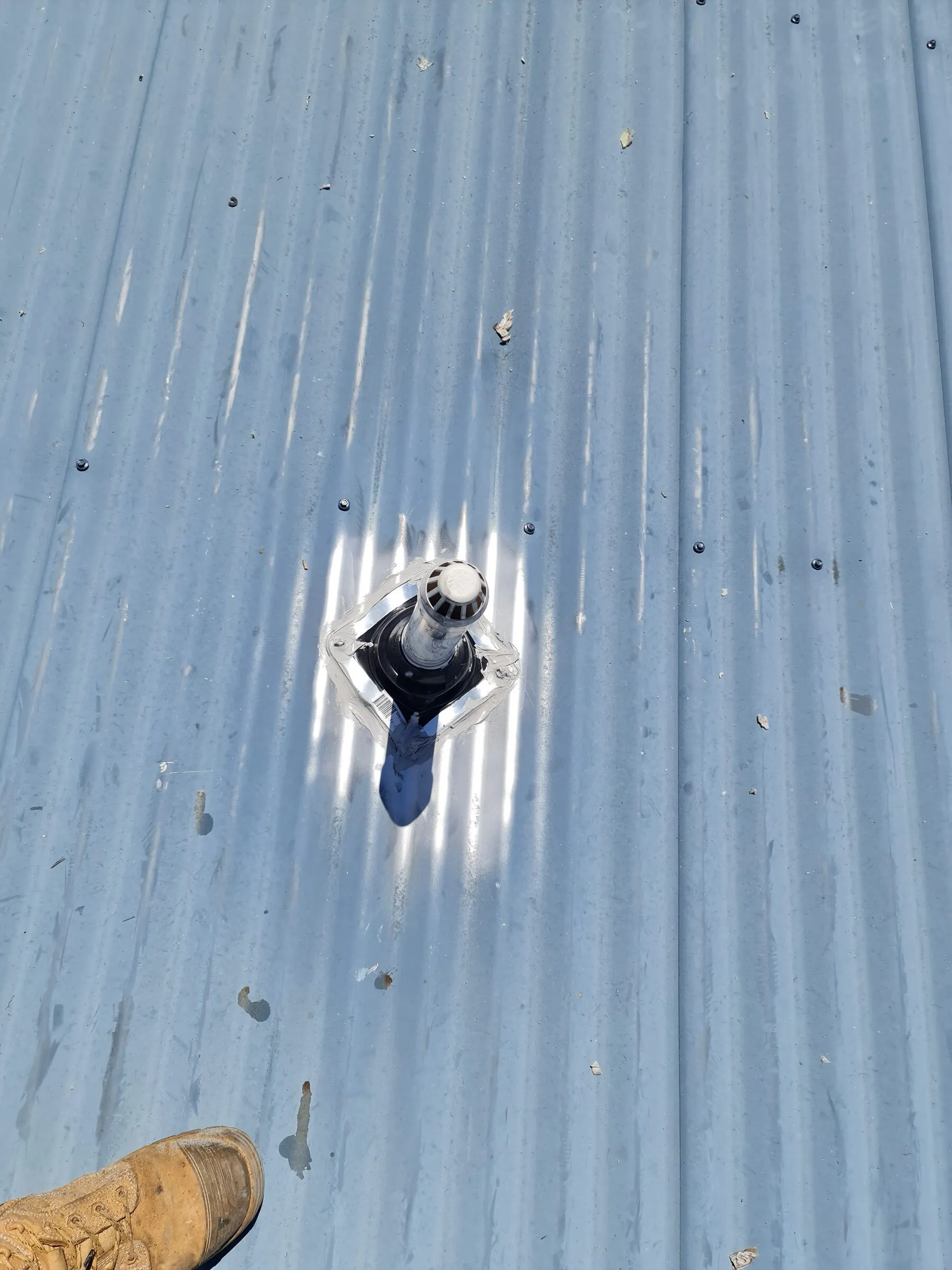 The replacement flashing boot seated and sealed square around the pipe.