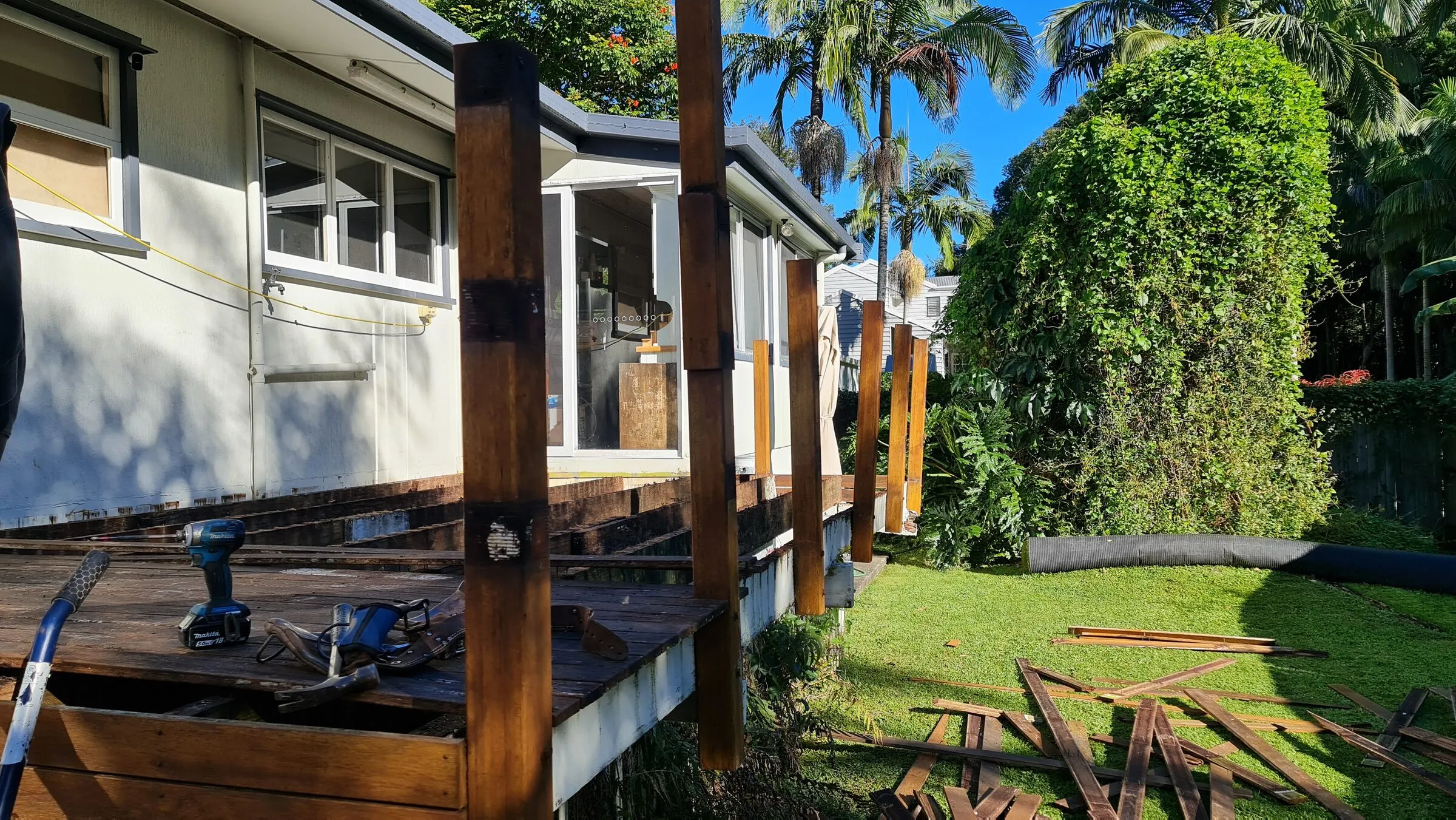 The stripped deck along the side of the house with the posts still standing.