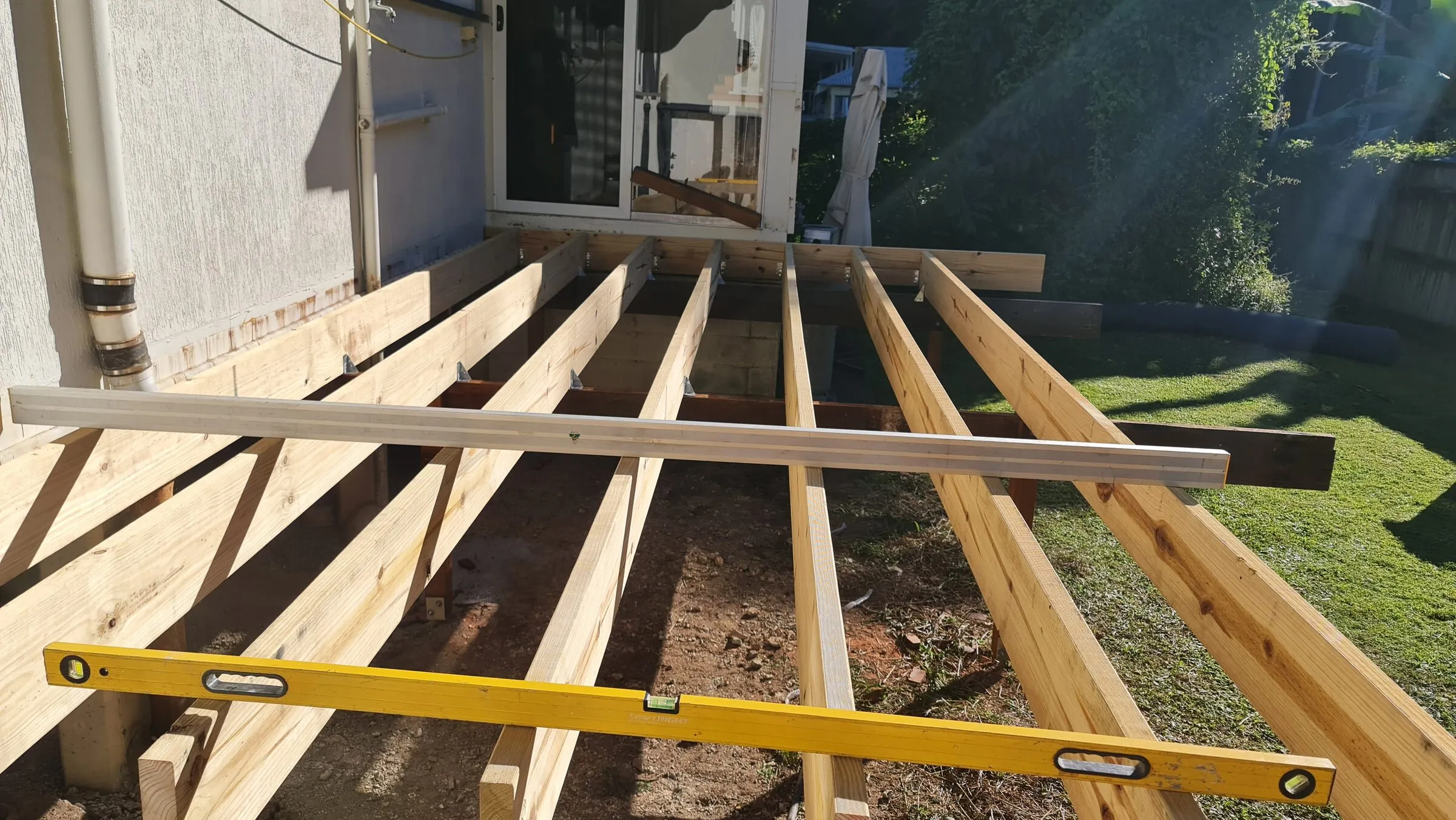 The new subfloor levelled across its length, straight edge and spirit level laid over it.