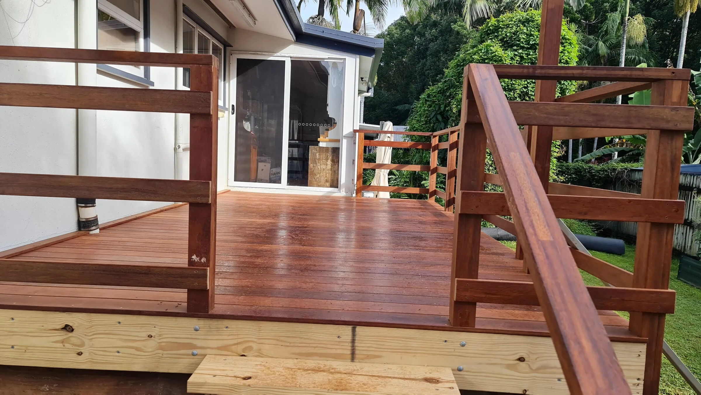 Hardwood boards laid and oiled, with the new balustrade going up around them.